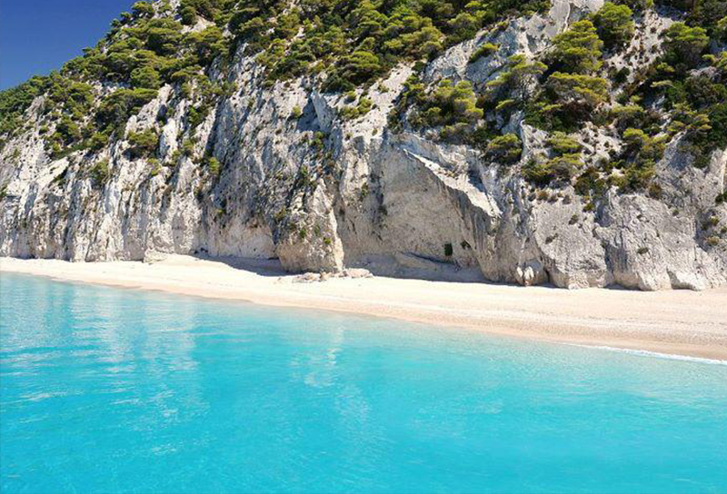 παραλία με καταγάλανα νερά και άγρια ομορφιά.